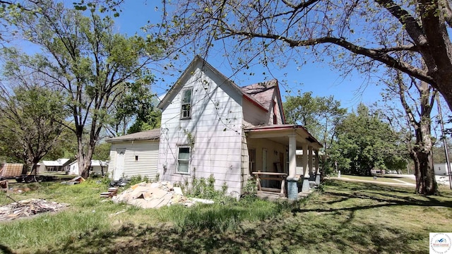 view of property exterior featuring a porch and a lawn