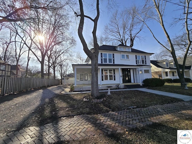 traditional style home with fence and a porch