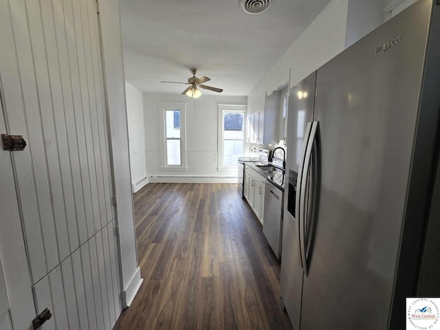 kitchen featuring baseboards, dark wood-style floors, stainless steel appliances, white cabinetry, and a sink