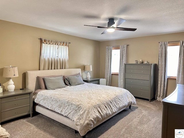bedroom with a ceiling fan, light carpet, and a textured ceiling