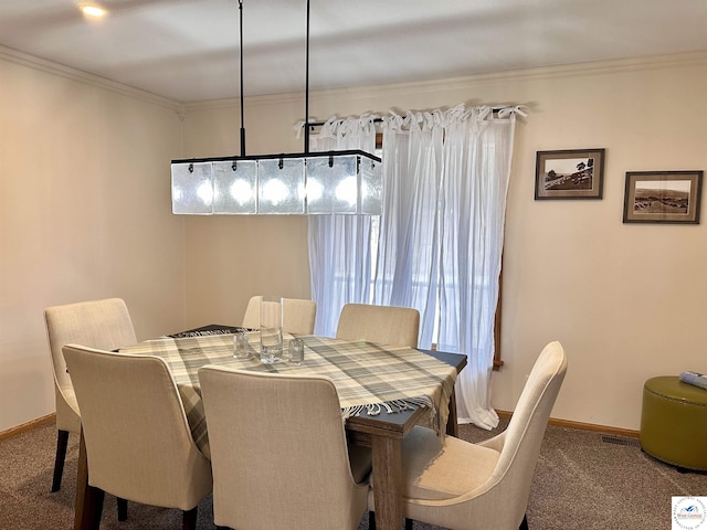 dining room featuring baseboards, carpet, visible vents, and crown molding