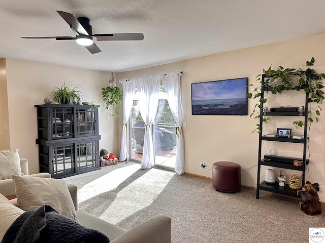 carpeted living room with a textured ceiling, baseboards, and a ceiling fan