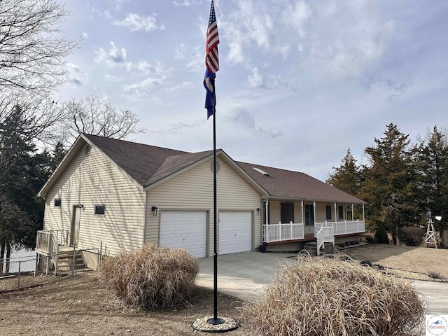 ranch-style house featuring a garage, concrete driveway, and covered porch
