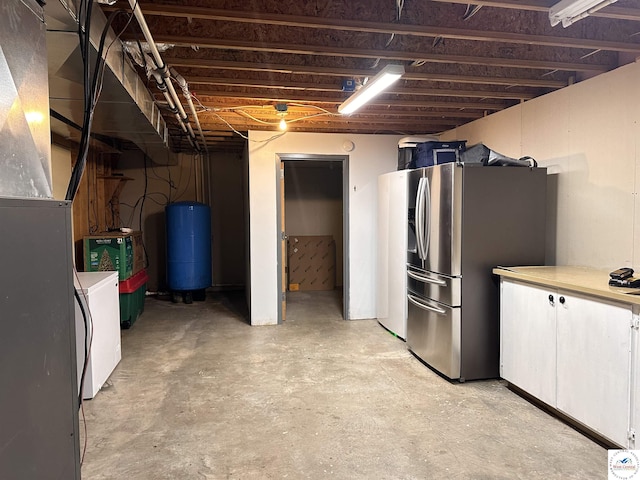 unfinished basement featuring washer / clothes dryer and stainless steel refrigerator with ice dispenser
