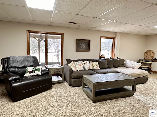 carpeted living area with a paneled ceiling and visible vents