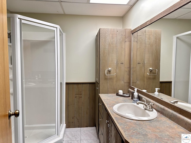 full bath featuring a paneled ceiling, a stall shower, tile patterned flooring, and vanity