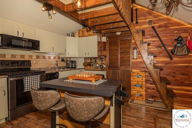 kitchen with electric range, dark countertops, dark wood finished floors, and black microwave