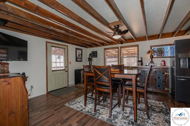 dining space featuring dark wood finished floors, beam ceiling, and ceiling fan