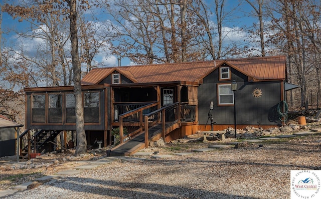 chalet / cabin with stairway, a sunroom, and metal roof