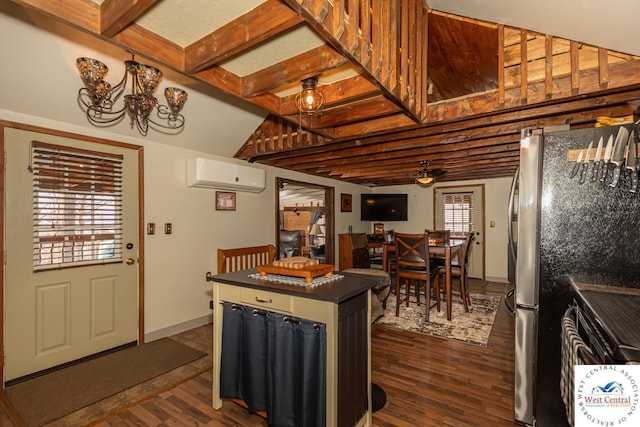 kitchen featuring dark countertops, dark wood finished floors, freestanding refrigerator, and a wall unit AC