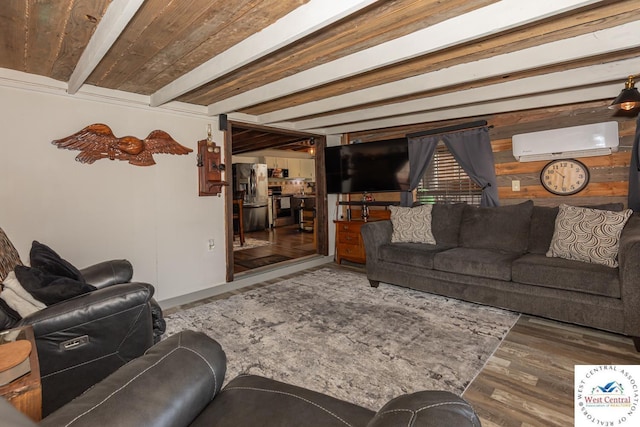 living area with beam ceiling, a wall unit AC, and wood finished floors