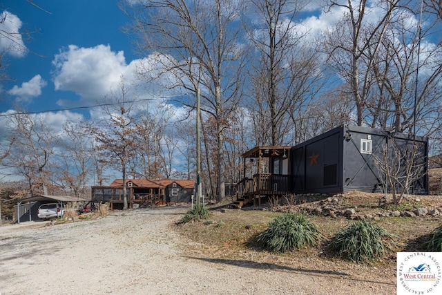 view of front facade with a carport and dirt driveway