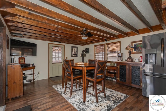 dining area featuring beamed ceiling, dark wood-type flooring, and ceiling fan