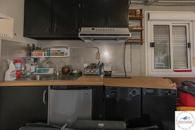 kitchen with a sink, under cabinet range hood, dark cabinetry, fridge, and open shelves