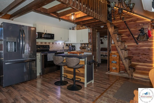 kitchen featuring beam ceiling, black appliances, dark countertops, white cabinets, and dark wood-style flooring