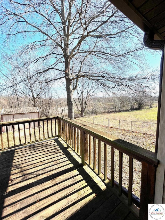 wooden deck with a rural view and fence