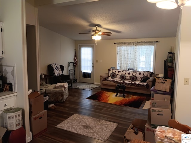 living area with dark wood finished floors, a textured ceiling, and ceiling fan