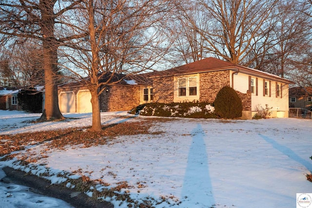 ranch-style house featuring an attached garage and brick siding