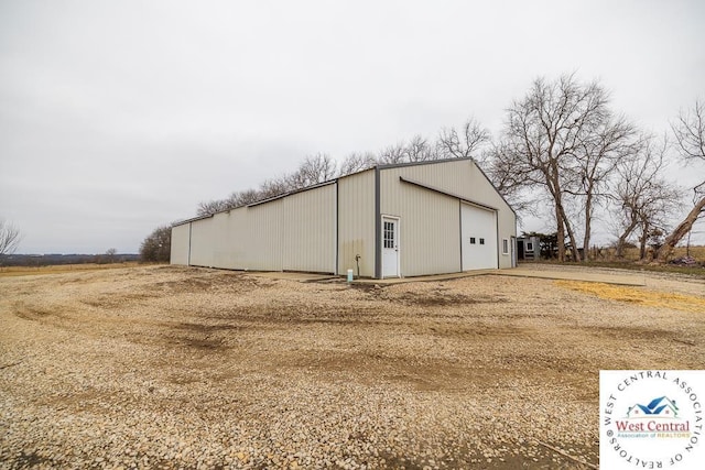 view of pole building with dirt driveway