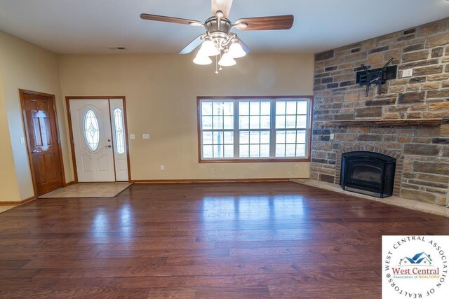 entrance foyer featuring a wealth of natural light, a fireplace, baseboards, and wood finished floors