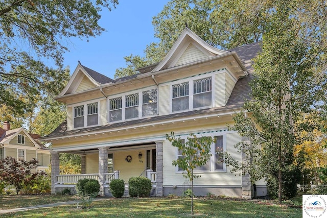 view of front of house with a porch and a front yard