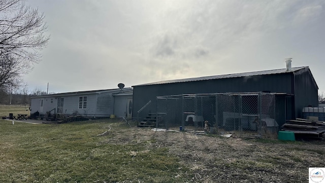 back of house with an outbuilding, a lawn, and an outdoor structure