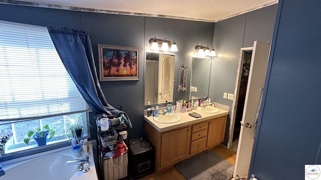 full bath featuring a sink, a garden tub, and double vanity