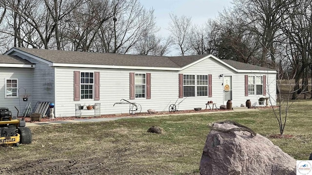 view of front of house featuring roof with shingles and a front lawn