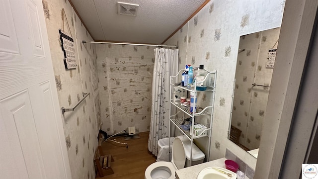 full bathroom with a shower with shower curtain, wood finished floors, visible vents, wallpapered walls, and a textured ceiling