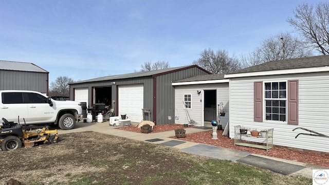 view of front of home with an outbuilding, an attached garage, and driveway