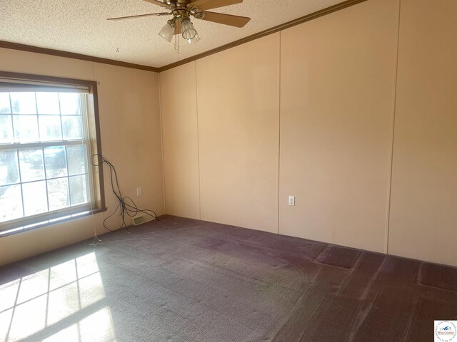 empty room with a textured ceiling, carpet, a ceiling fan, and crown molding