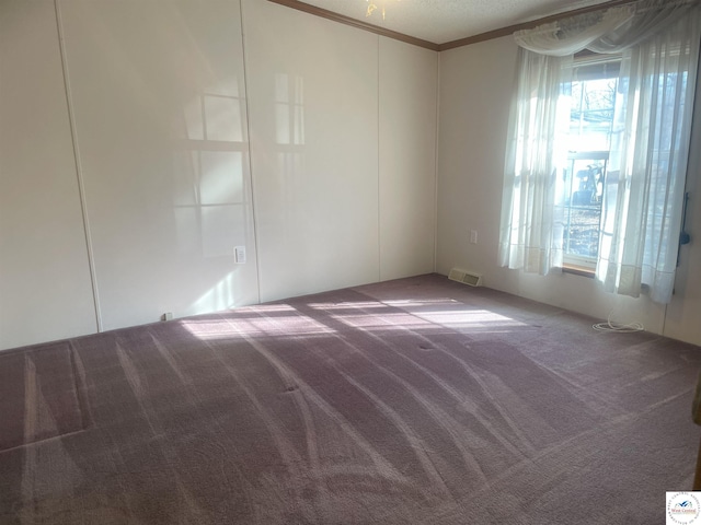 carpeted empty room with ornamental molding and visible vents