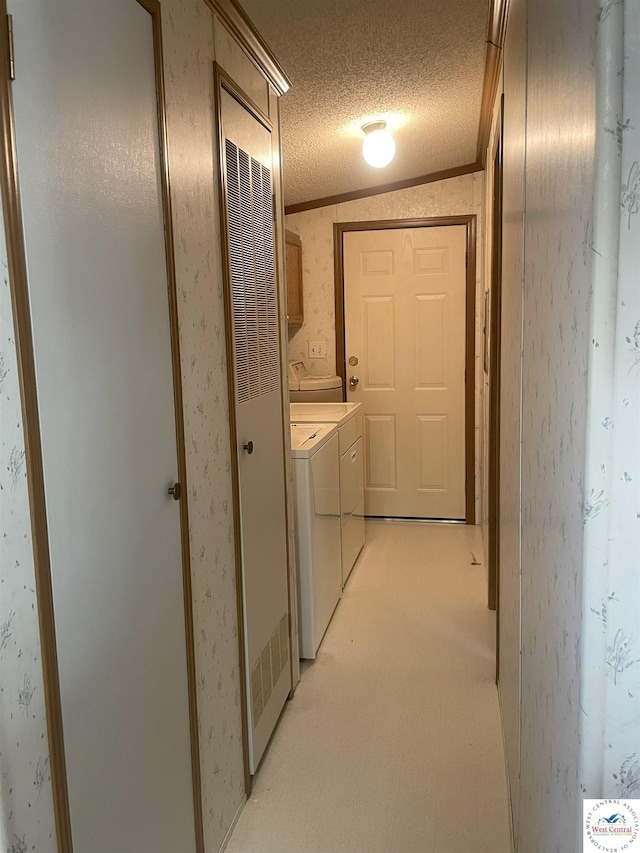 hall with crown molding, light floors, washing machine and dryer, a textured ceiling, and wallpapered walls