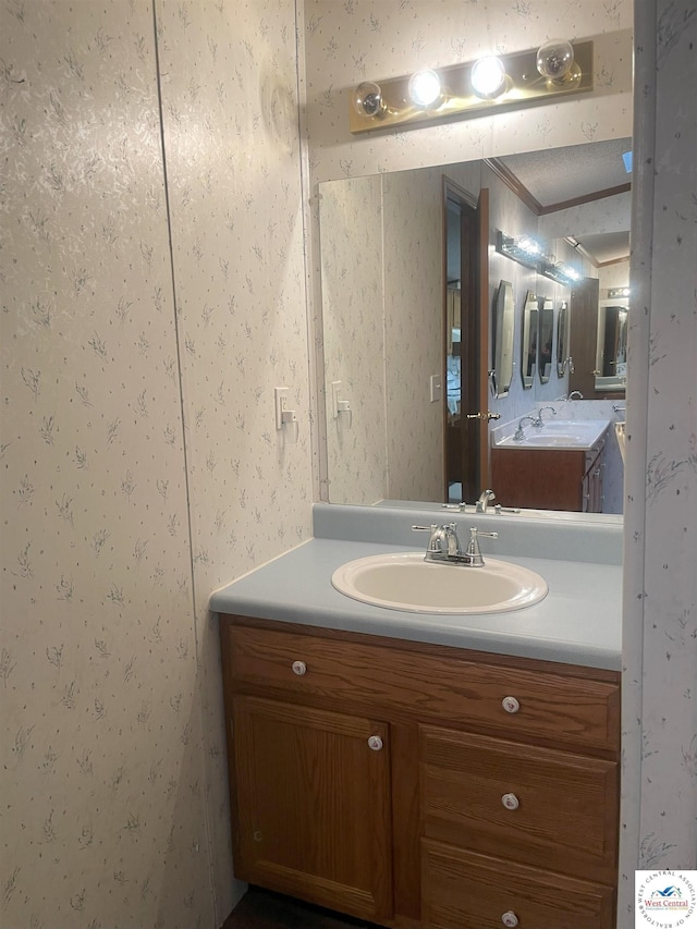 bathroom featuring vanity and wallpapered walls