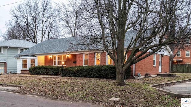 ranch-style home with a shingled roof and brick siding