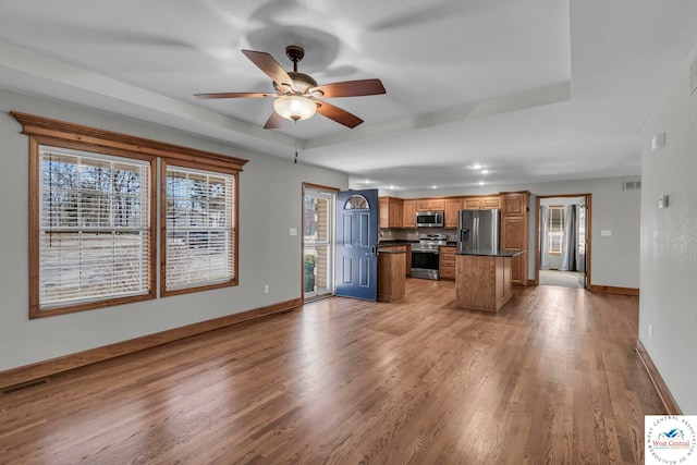 kitchen featuring visible vents, baseboards, light wood-style floors, appliances with stainless steel finishes, and dark countertops