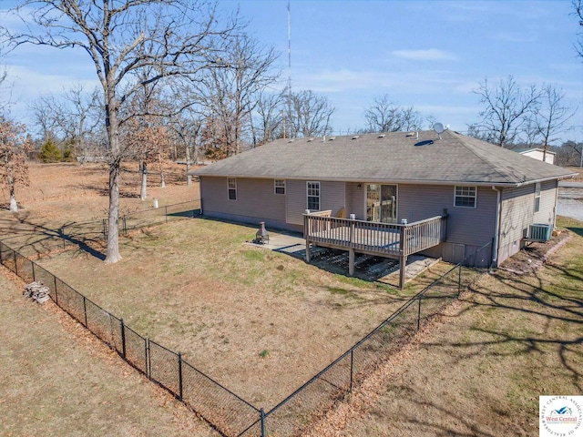 rear view of house with a wooden deck, roof with shingles, fence, a yard, and central AC