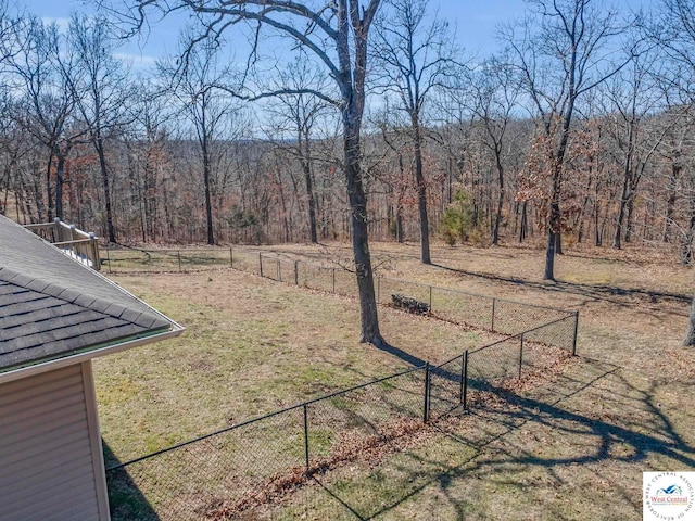 view of yard with fence and a view of trees