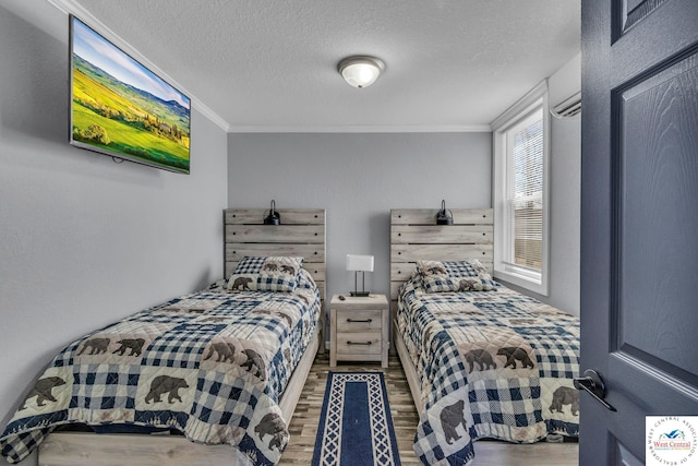 bedroom with a wall mounted air conditioner, crown molding, a textured ceiling, and wood finished floors