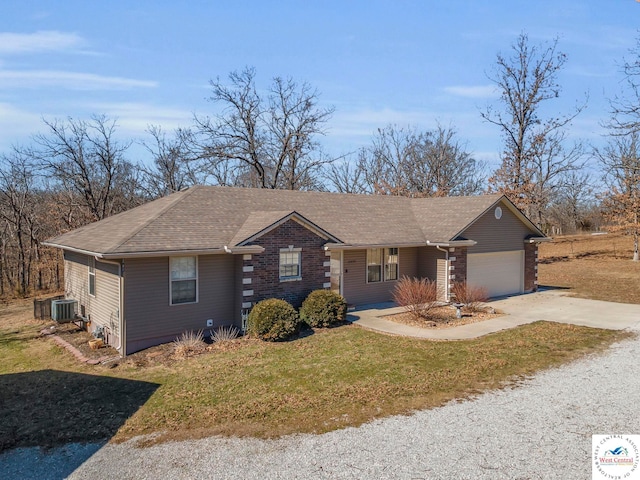 view of front facade with a garage, central AC, concrete driveway, roof with shingles, and a front lawn