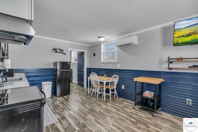 interior space featuring a wainscoted wall, an AC wall unit, exhaust hood, and freestanding refrigerator