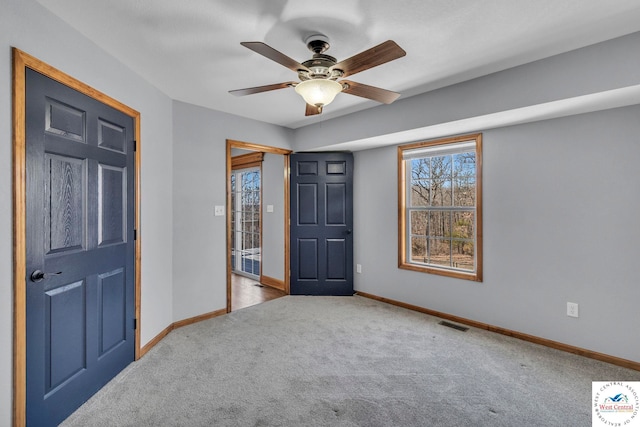 unfurnished bedroom with carpet floors, visible vents, baseboards, and a ceiling fan