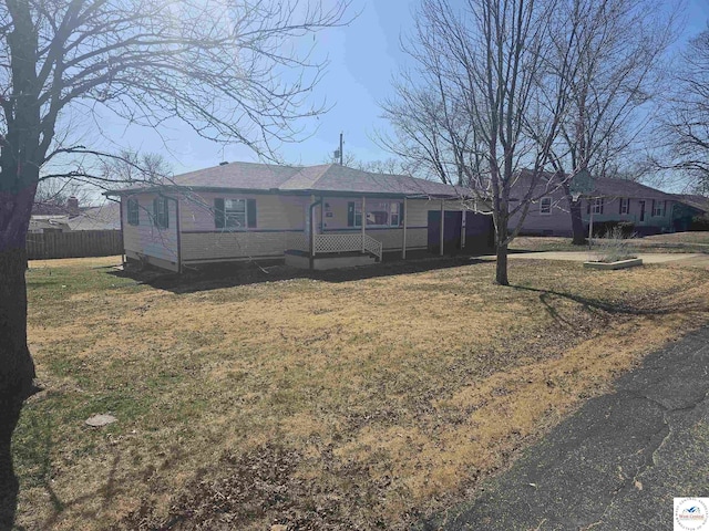 single story home with a front lawn and fence