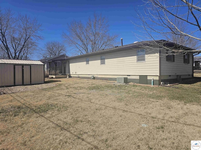 back of house featuring an outbuilding, cooling unit, a shed, a yard, and crawl space