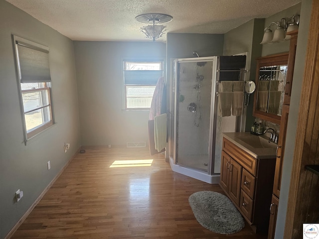 bathroom with a stall shower, wood finished floors, and vanity