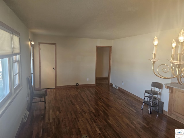 unfurnished living room featuring dark wood finished floors, visible vents, and baseboards