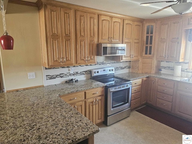 kitchen featuring light stone countertops, ceiling fan, stainless steel appliances, glass insert cabinets, and backsplash