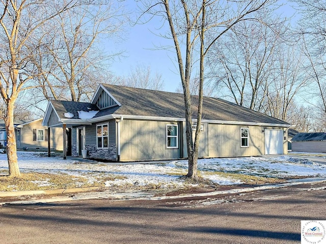 view of front of house with driveway and stone siding