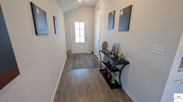 doorway to outside with lofted ceiling, visible vents, baseboards, and wood finished floors