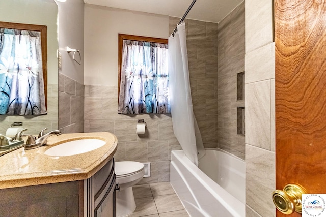 bathroom featuring vanity, tile patterned flooring, tile walls, toilet, and shower / tub combo with curtain